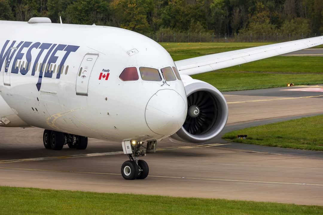 WestJet Boeing 787 Dreamliner taxiing on a runway in Scotland, showcasing modern aviation.