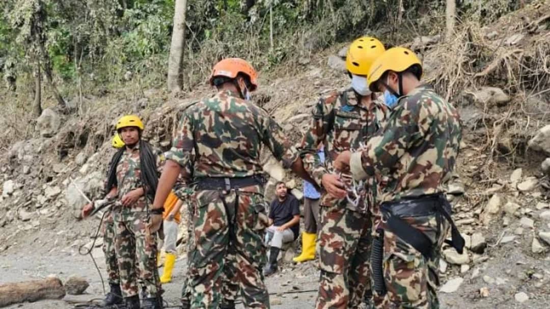 Nepal Army personnel in helmets and harnesses working on a debris slope above the Upper Trishuli 3B tunnel in Nuwakot