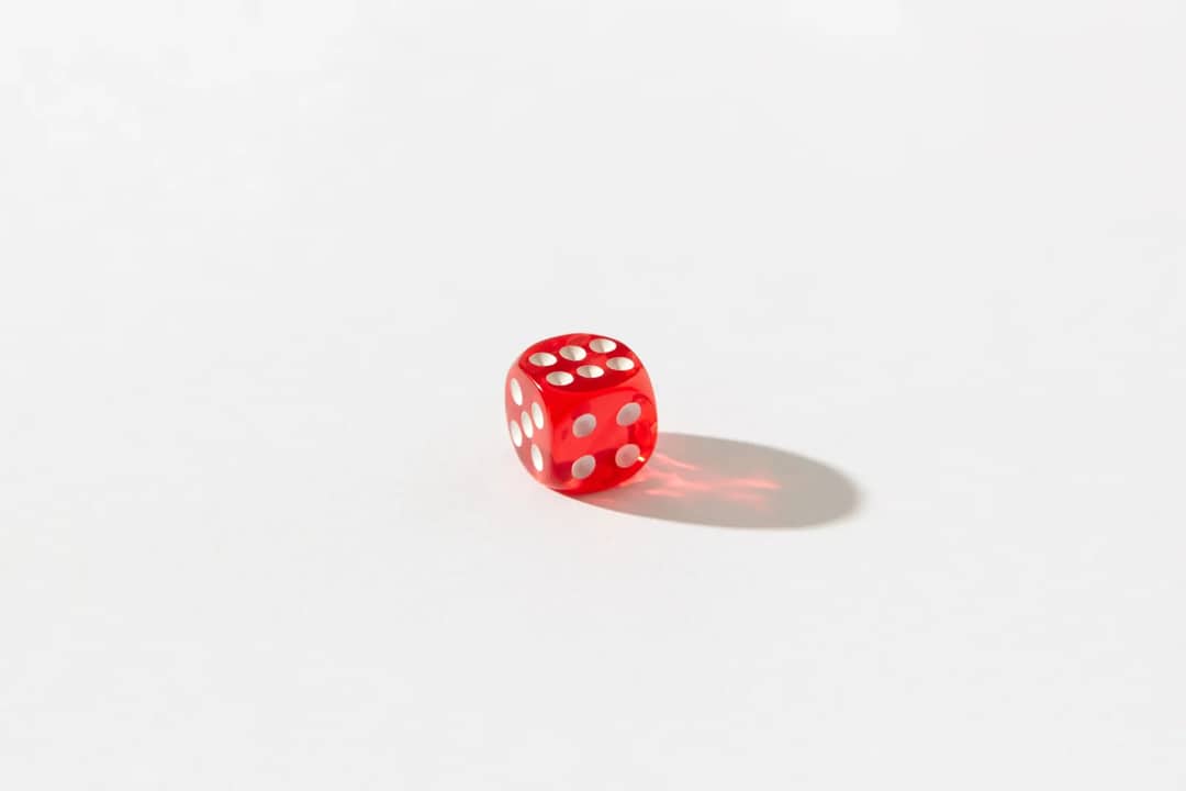Red dice with white dots on a plain white background, highlighting simplicity and chance.