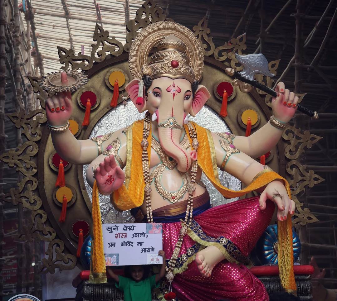 Vibrant statue of Lord Ganesha at a festival parade, showcasing cultural traditions and artistry.