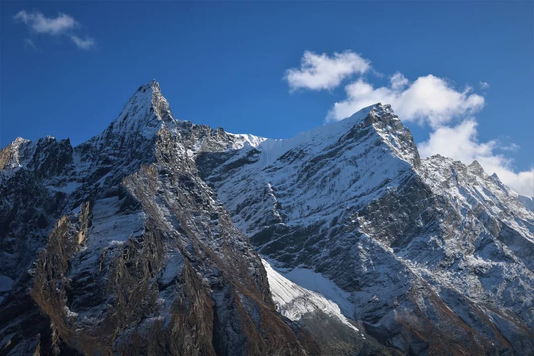 Stunning view of snow-covered mountains in Gorkha, Nepal against a clear blue sky.