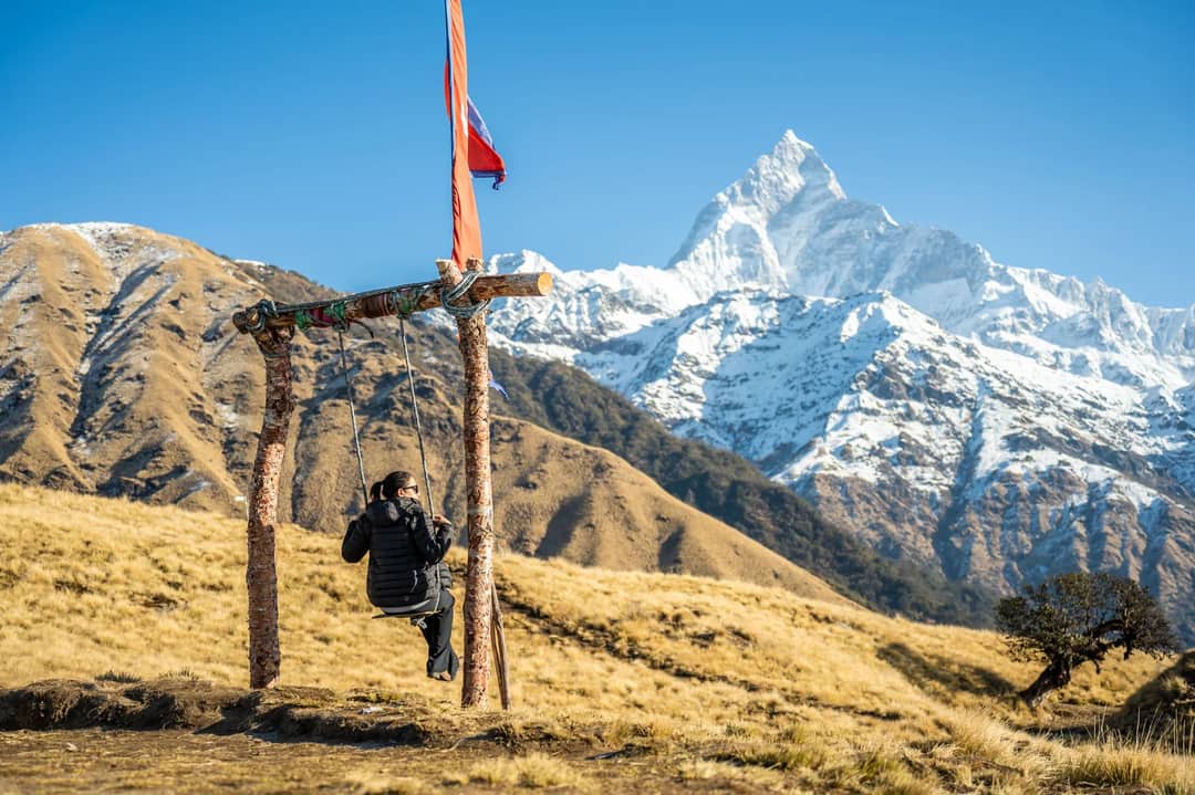 A woman enjoys a swing with a stunning view of the Annapurna mountain range in Pokhara, Nepal.