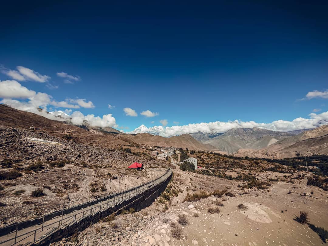 Explore the rugged terrain of Gandaki Province, Nepal, featuring a stunning mountain view under a vibrant blue sky.