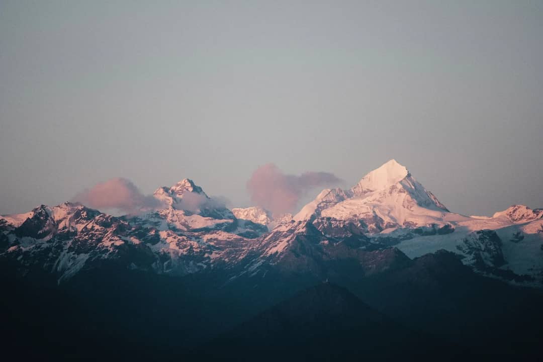 Stunning view of a snow-capped mountain range bathed in soft sunset light.