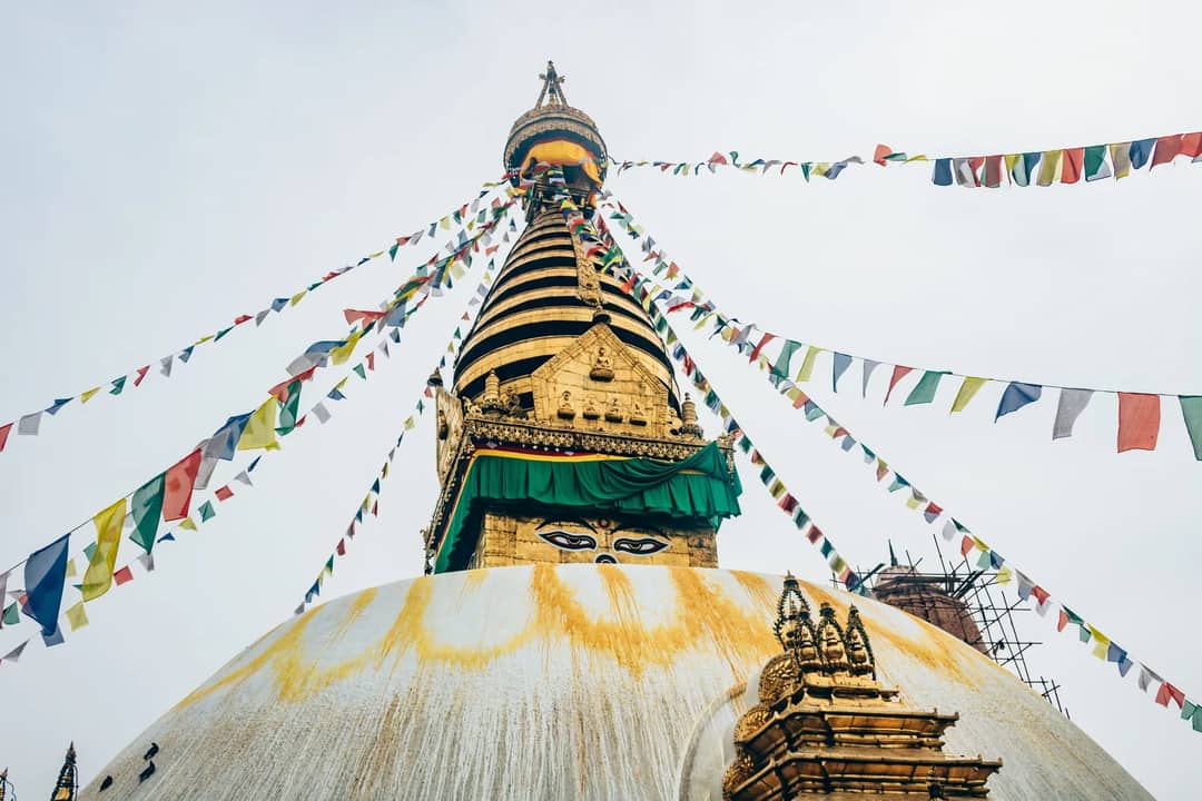 A stunning view of Swayambhunath Stupa adorned with colorful prayer flags in Kathmandu, Nepal.