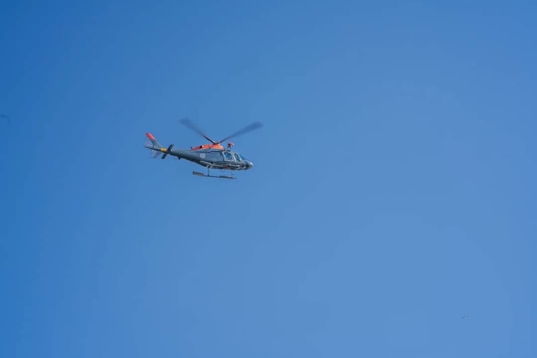 A single helicopter in flight against a bright blue sky, showcasing aviation technology.
