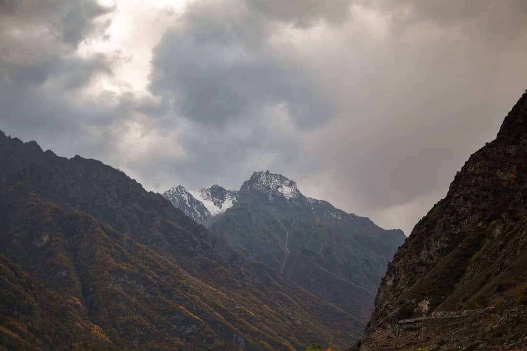 A breathtaking view of mountains under thick clouds, showcasing nature's dramatic beauty.