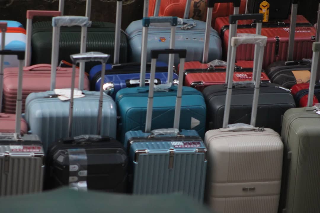 Rows of rigid hard-shell suitcases — the shell spreads impact and locks all the way round, at the cost of weight and scratches