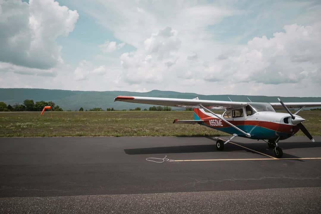 A small propeller aircraft parked on a rural airstrip