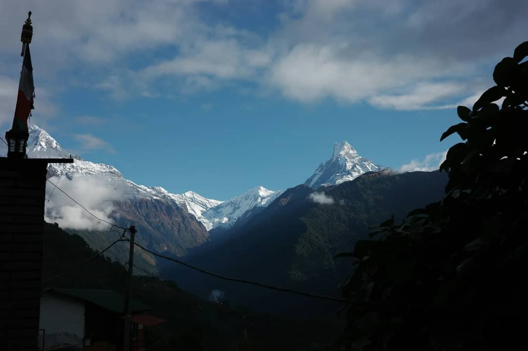 Snow-capped mountains under a cloudy blue sky