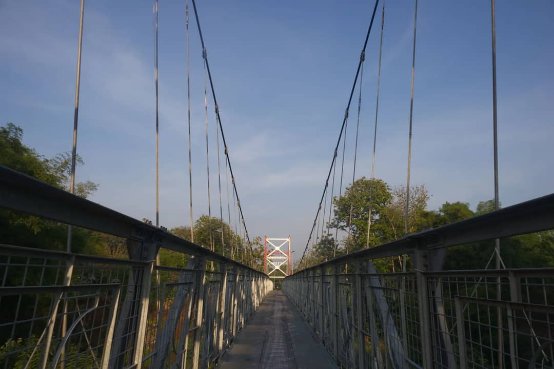 A long steel suspension bridge across a river valley