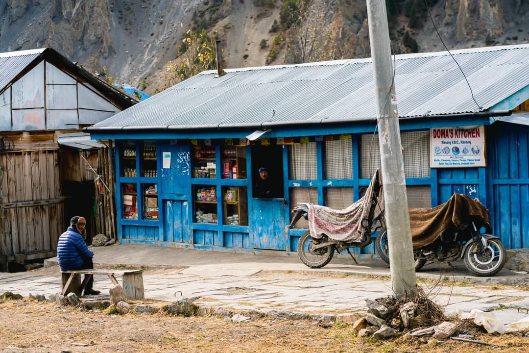 A blue timber shop and café in a mountain village