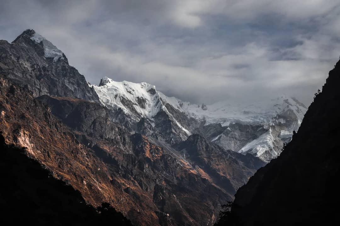 Snow peaks above a dark valley in the Nepal Himalaya