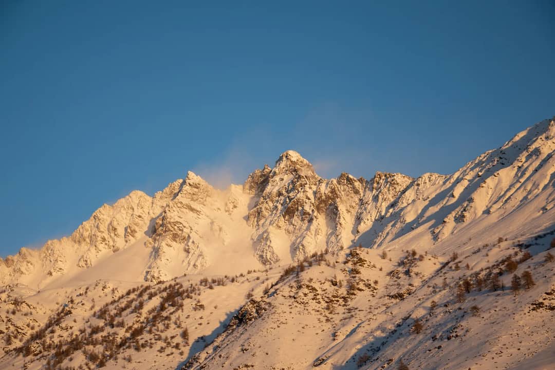 Breathtaking view of snow-covered peaks during sunrise in Ponte di Legno, Lombardia.