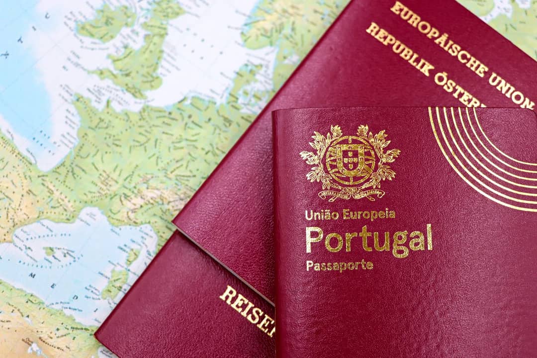 Close-up of Portuguese and Austrian passports lying on a map of Europe, symbolizing travel and mobility.