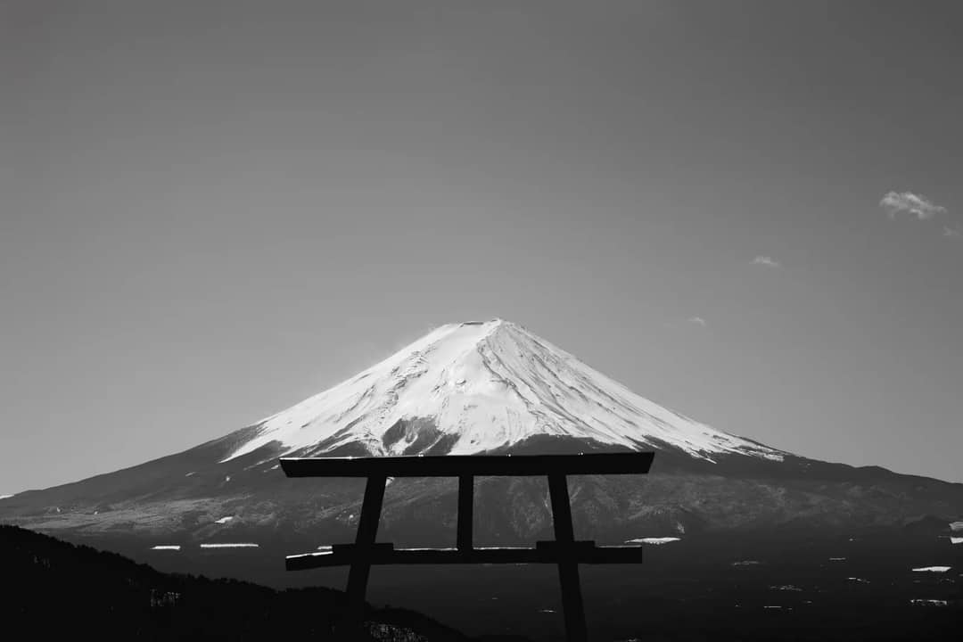 Black and white image of Mount Fuji with a Torii gate silhouette in Fujikawaguchiko, Japan.