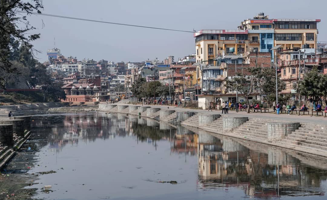 Bustling urban scene along Bagmati River in Kathmandu, Nepal capturing local life and architecture.