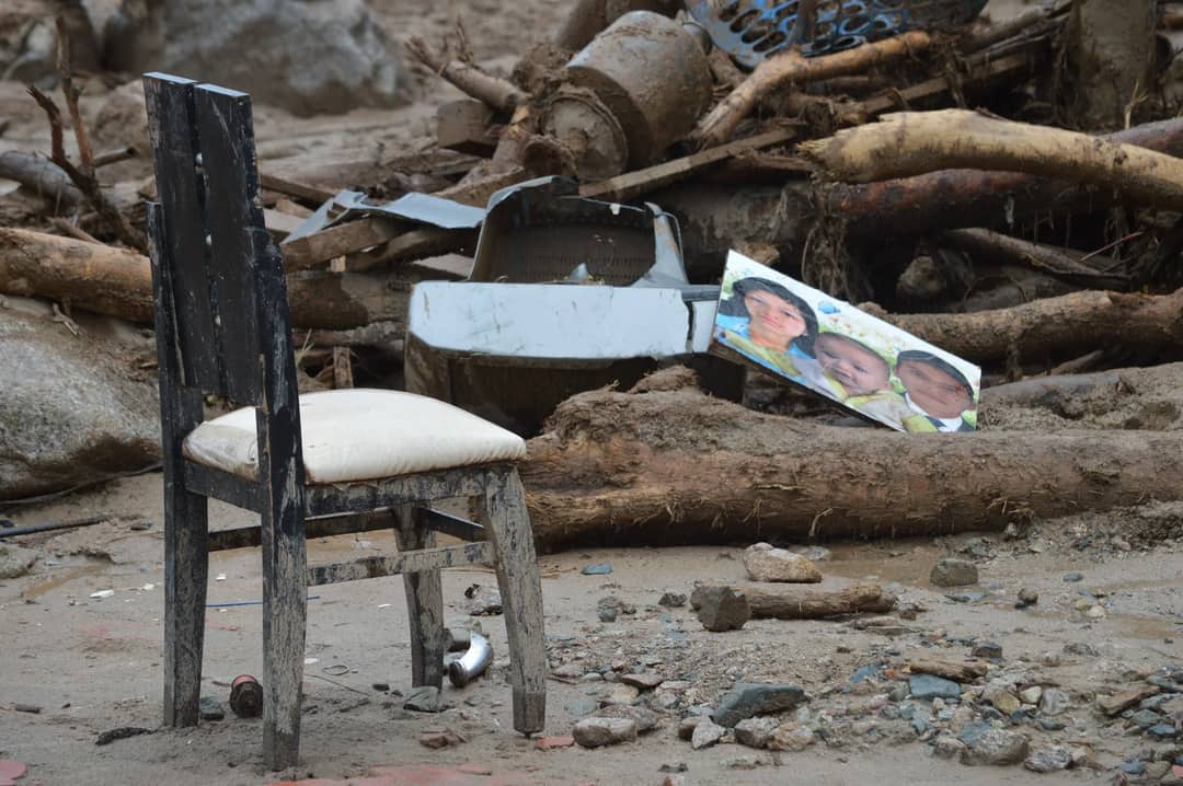 Destruction in Mocoa, Colombia shows a damaged chair amidst debris and rubble, highlighting natural disaster's impact.