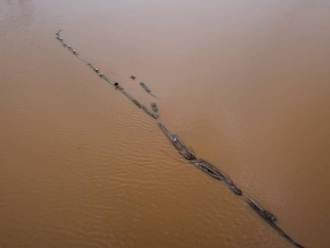 A swollen, muddy river carrying debris