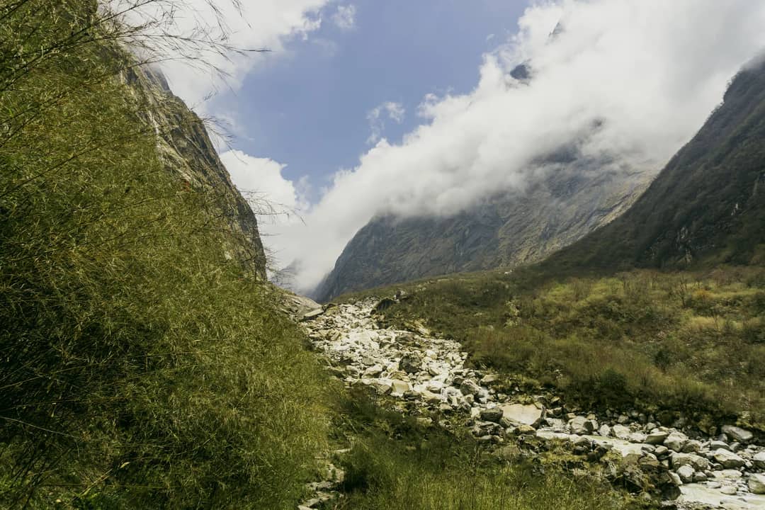 Breathtaking view of a valley in Annapurna, Nepal, showcasing dramatic mountains and lush greenery.