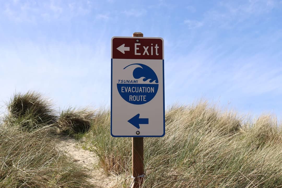 Tsunami evacuation route sign at Cannon Beach, Oregon, guiding beachgoers to safety.