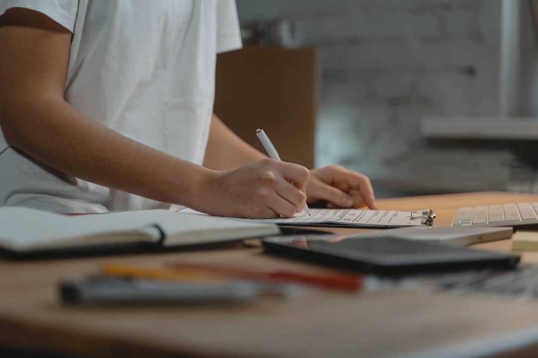 A checklist being written in a notebook
