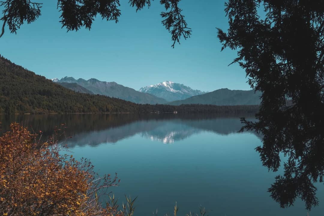 Majestic mountain landscape with cloudy skies over a serene lake in Karnali Province, Nepal.