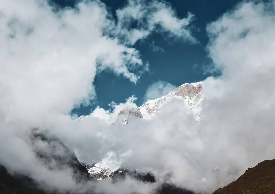 A snow peak appearing through cloud