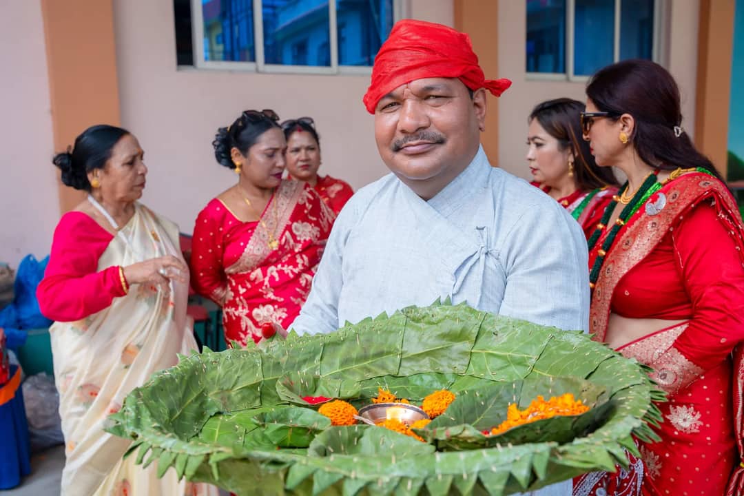 A Nepalese man in traditional attire holds a decorative leaf platter during a festival
