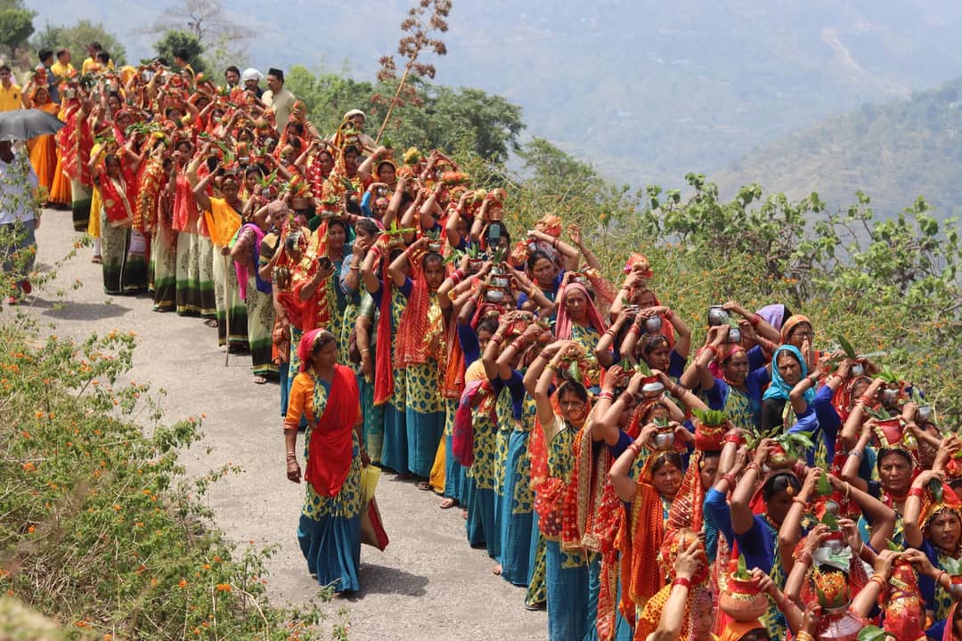 A parade of women in traditional clothing celebrating on a rural road