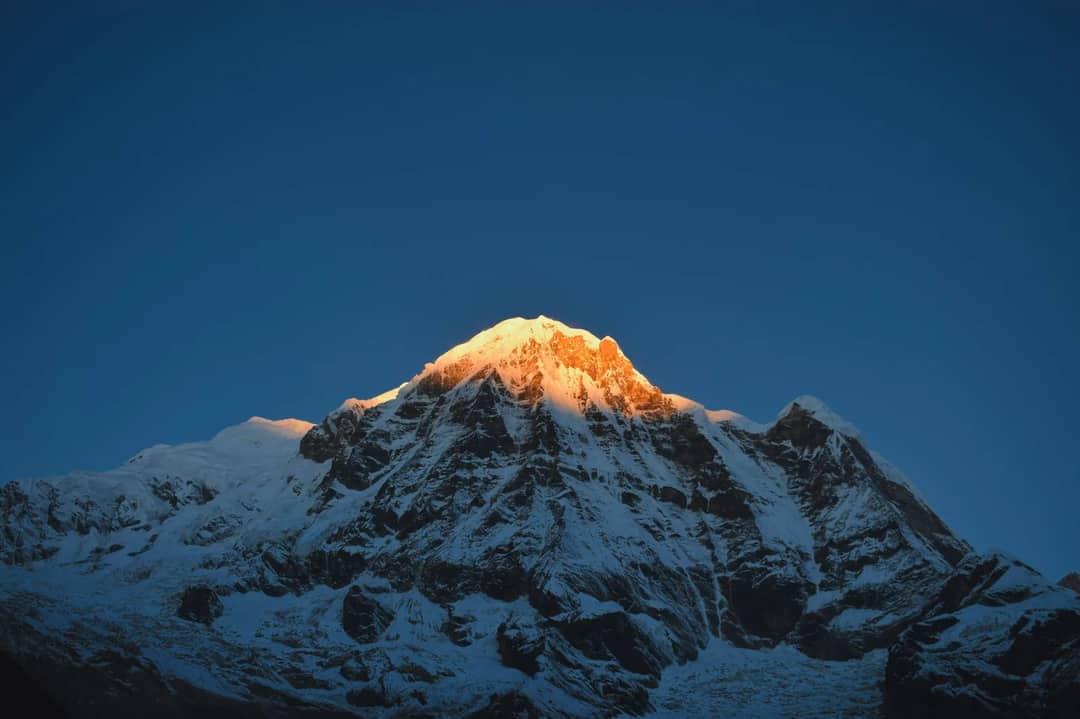 a snow covered mountain with a blue sky in the background