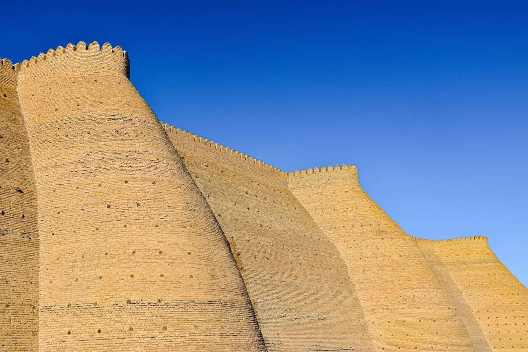 Stunning view of Ichan Kala's ancient fort walls under a clear blue sky in Khiva, Uzbekistan.