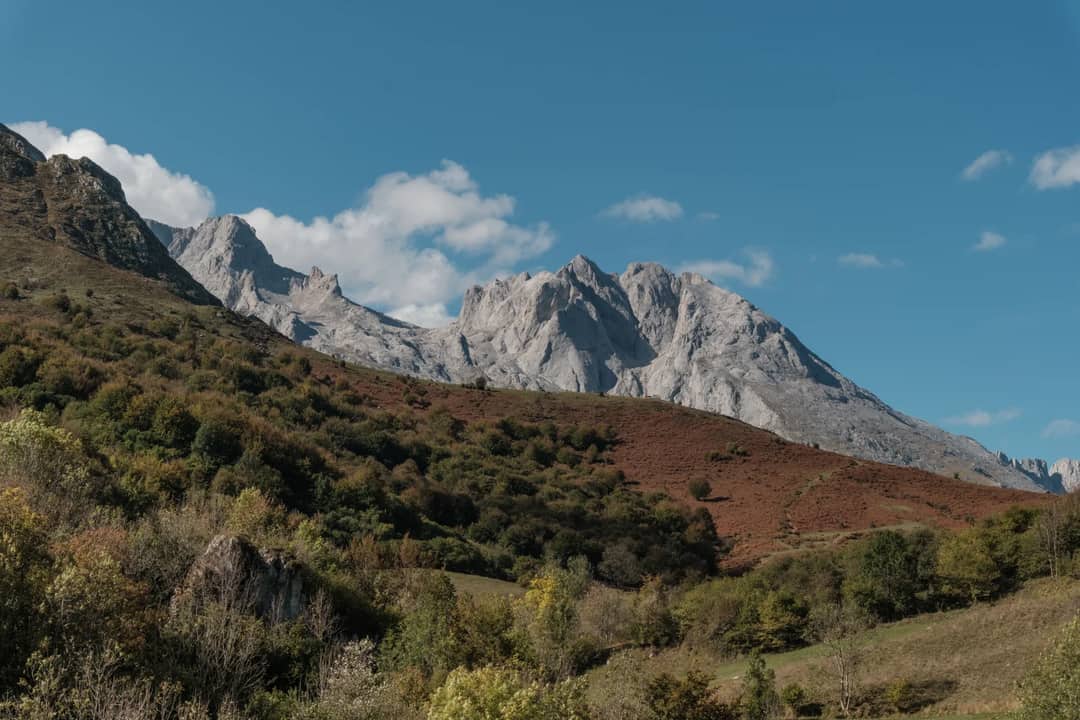 Explore the breathtaking mountain landscape in Asturias, Spain with lush greenery and clear skies.