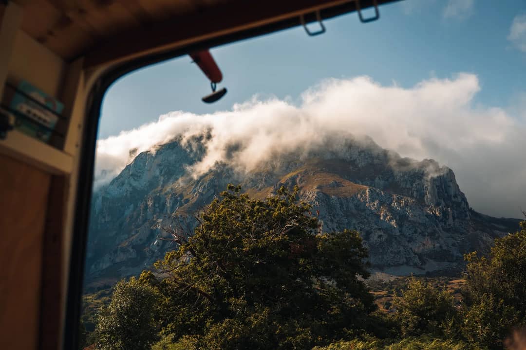 Stunning view of a cloudy mountain through a van window in the Spanish countryside.