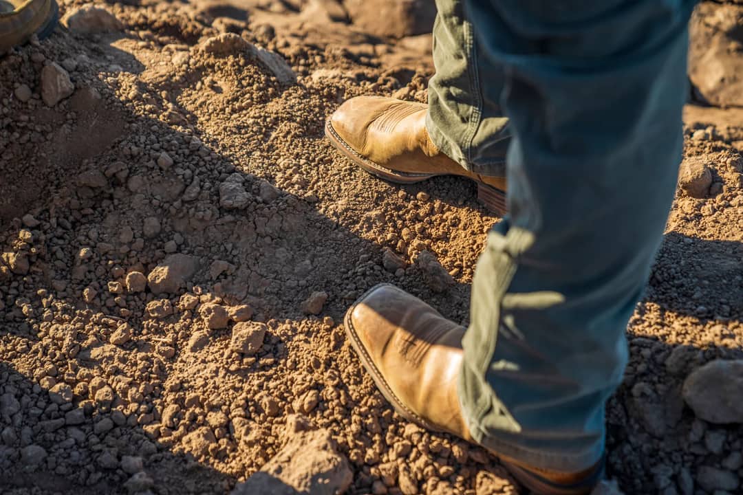 A booted foot placed on uneven rock, the ground on which the ankle-support claim is usually made