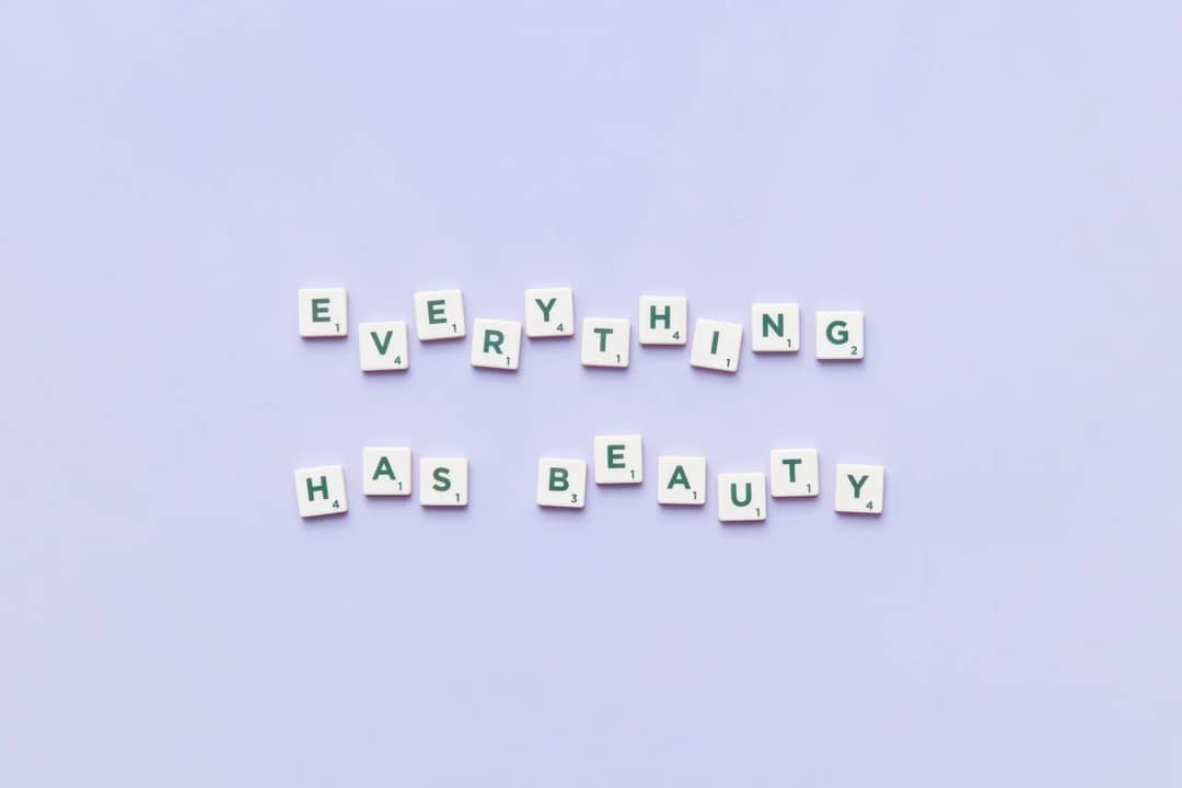 "Everything Has Beauty" spelled with Scrabble tiles on a blue background.