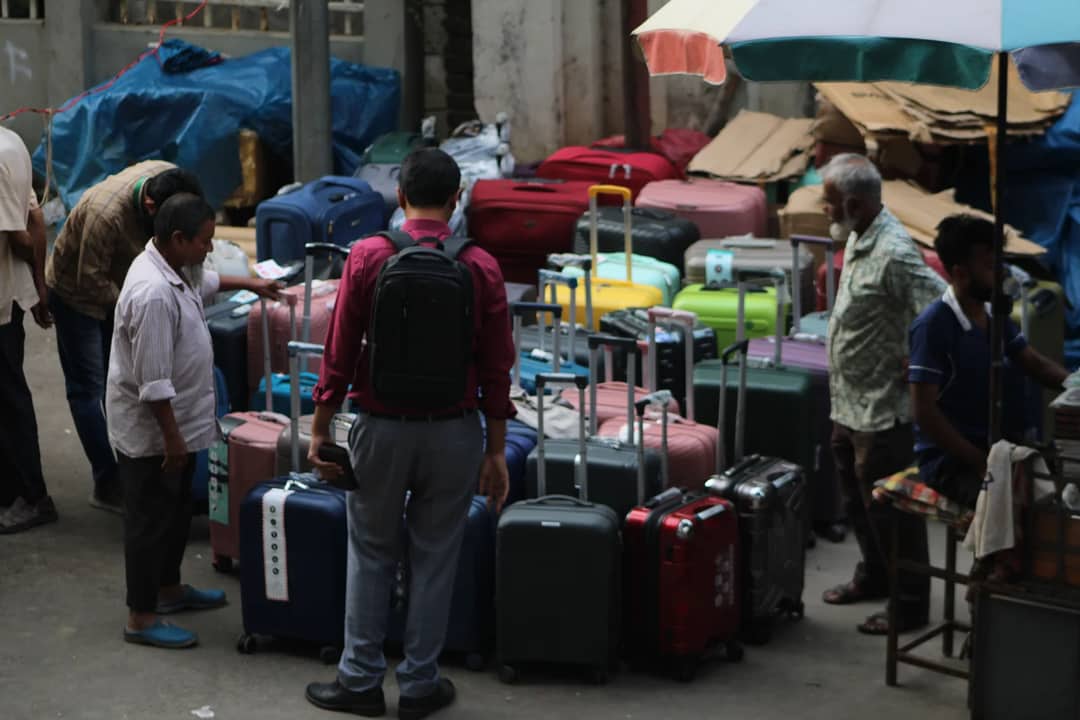 Street market scene with people browsing various colorful suitcases.