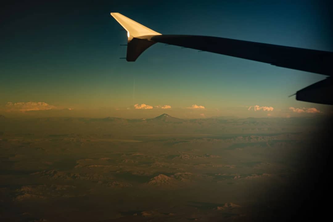 Scenic aerial view of mountains and clouds from an airplane window over Iquique, Chile.