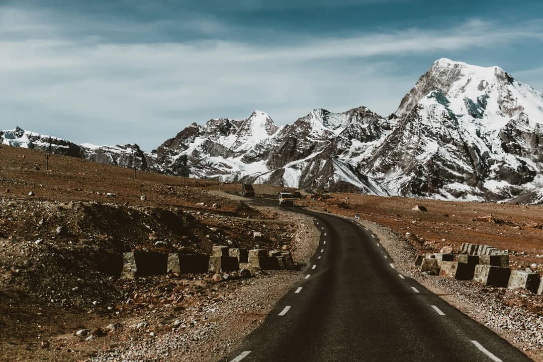 A stunning view of a winding road through snowcapped mountains, perfect for travel and adventure enthusiasts.
