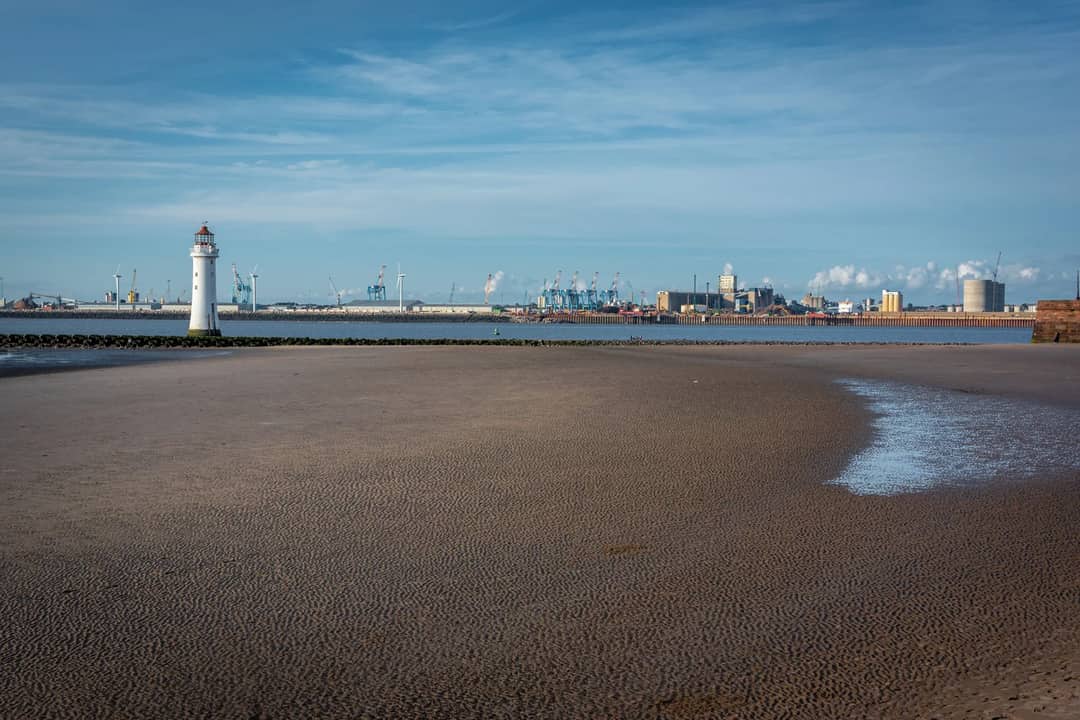 New Brighton Lighthouse with coastal scenery and blue sky in England, UK.