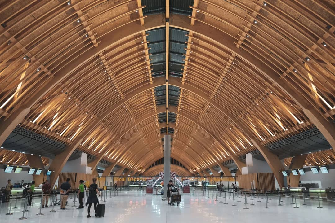 A spacious and modern interior view of Mactan-Cebu Airport terminal with wooden architecture.