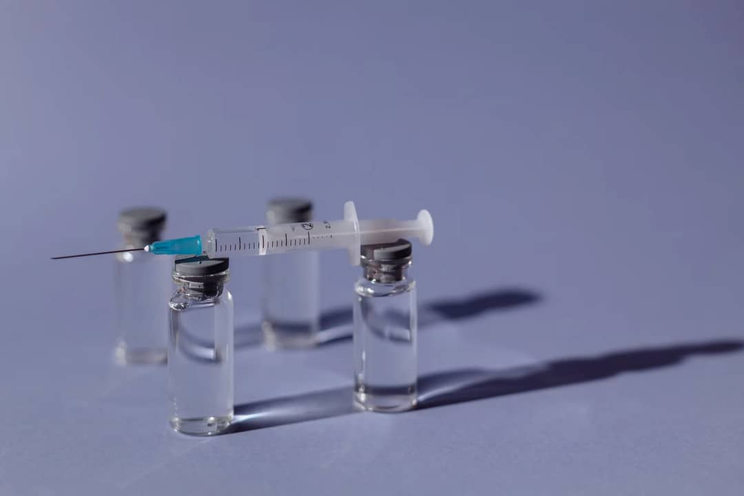 A vaccine vial and syringe in a clinic