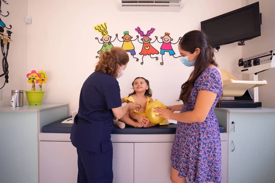 A doctor examining a young child at a paediatric clinic