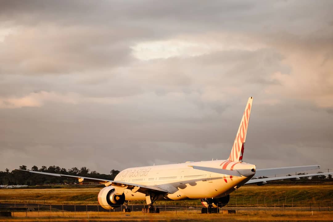Virgin Australia Boeing 777 on tarmac at Wellcamp Airport during golden hour.