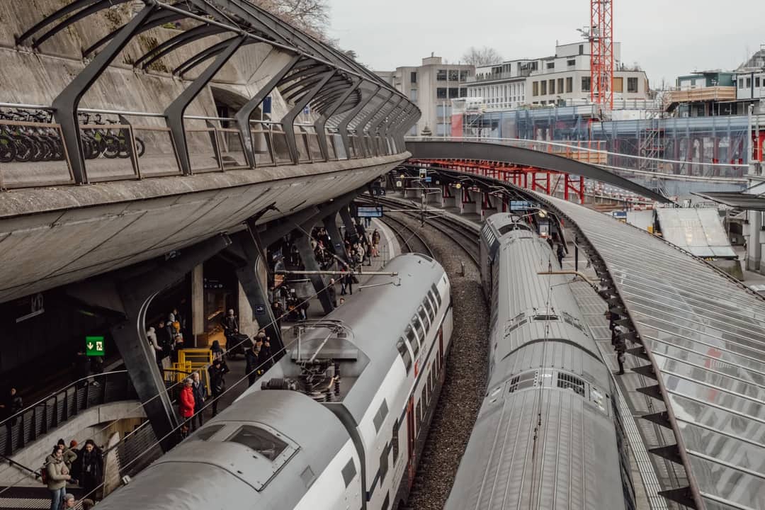 Aerial view of bustling train station in Zurich, Switzerland with modern architecture and commuter activity.