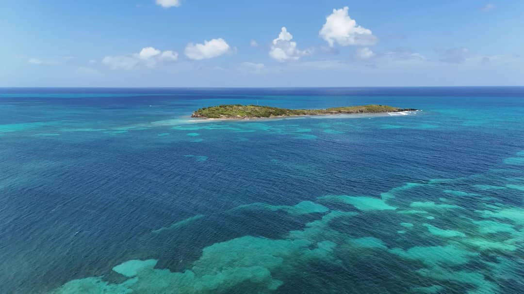 A small island in clear turquoise Caribbean water