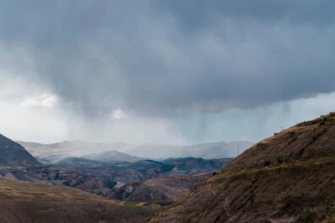 Vibrant Andean landscape in Jauja, Peru with dramatic cloud formations and rugged mountains.