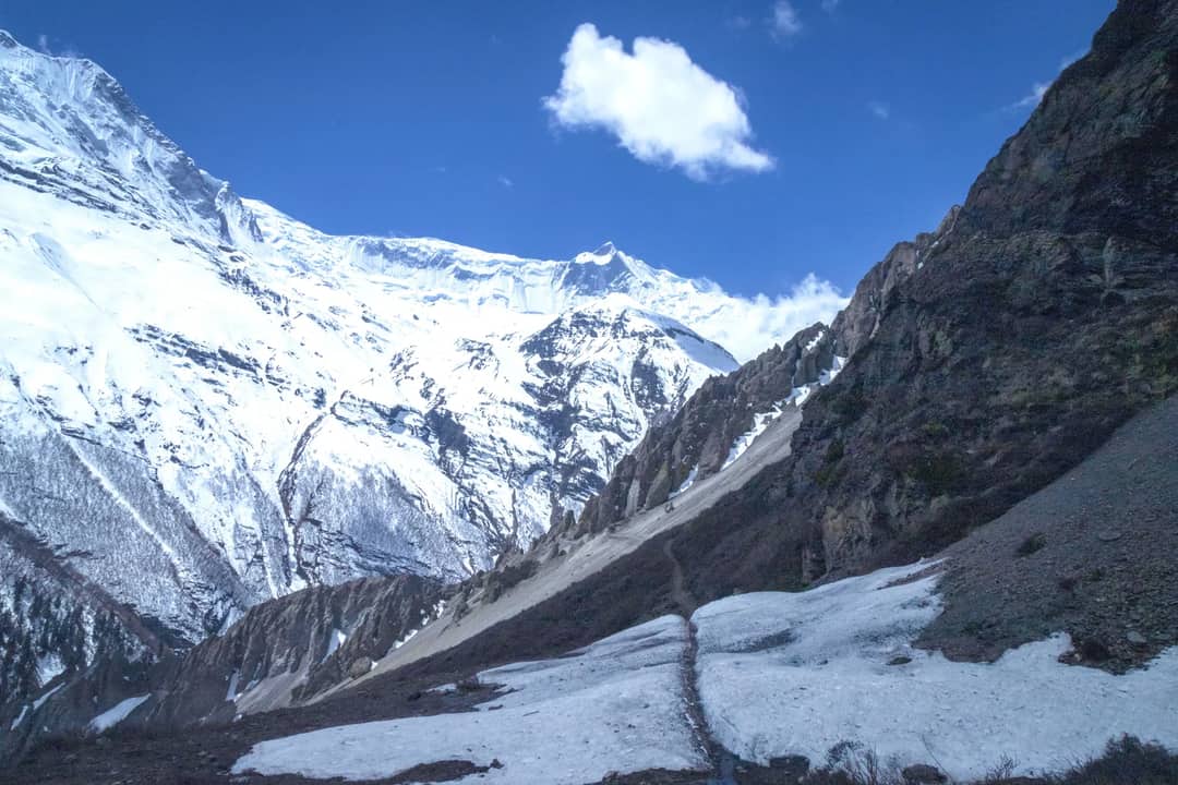 Scenic view of snow-covered mountains in Manang, Nepal with clear blue sky.
