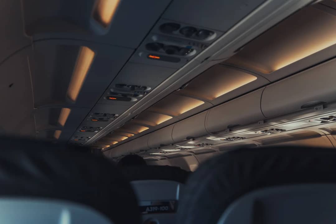 An empty airliner cabin — the drop-down oxygen masks above these seats hold ten to fifteen minutes