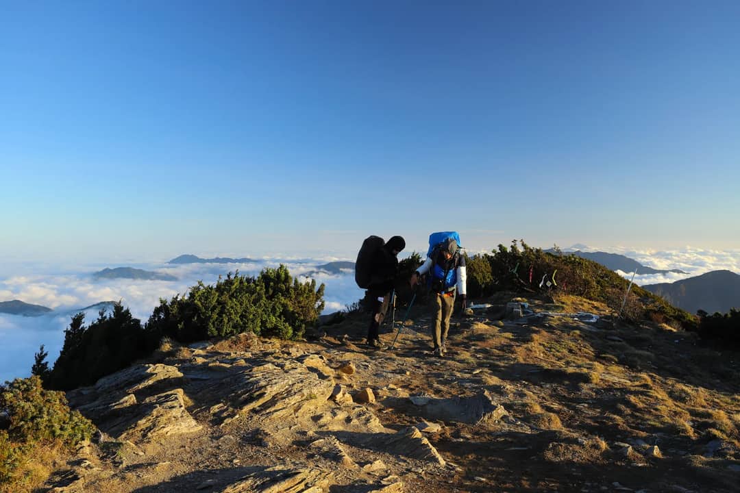 Adventurers climb a mountain in Taiwan, capturing stunning clouds and landscapes.